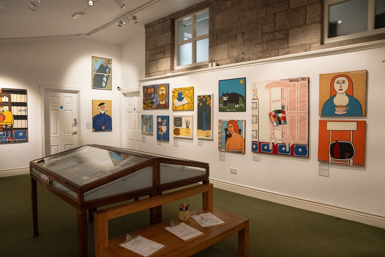 A wall of paintings by Terry Shaul in the gallery