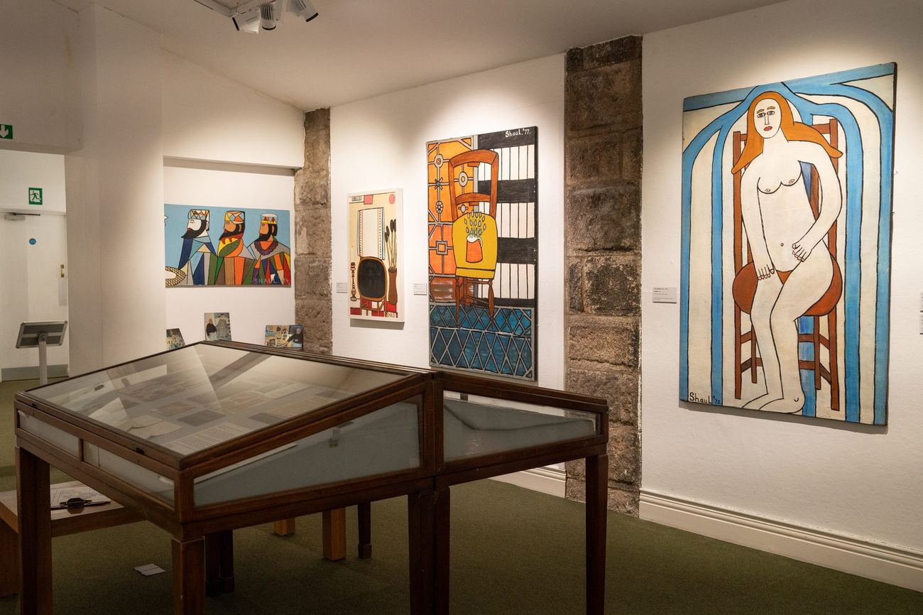 The main gallery, with display cases and paintings on three walls