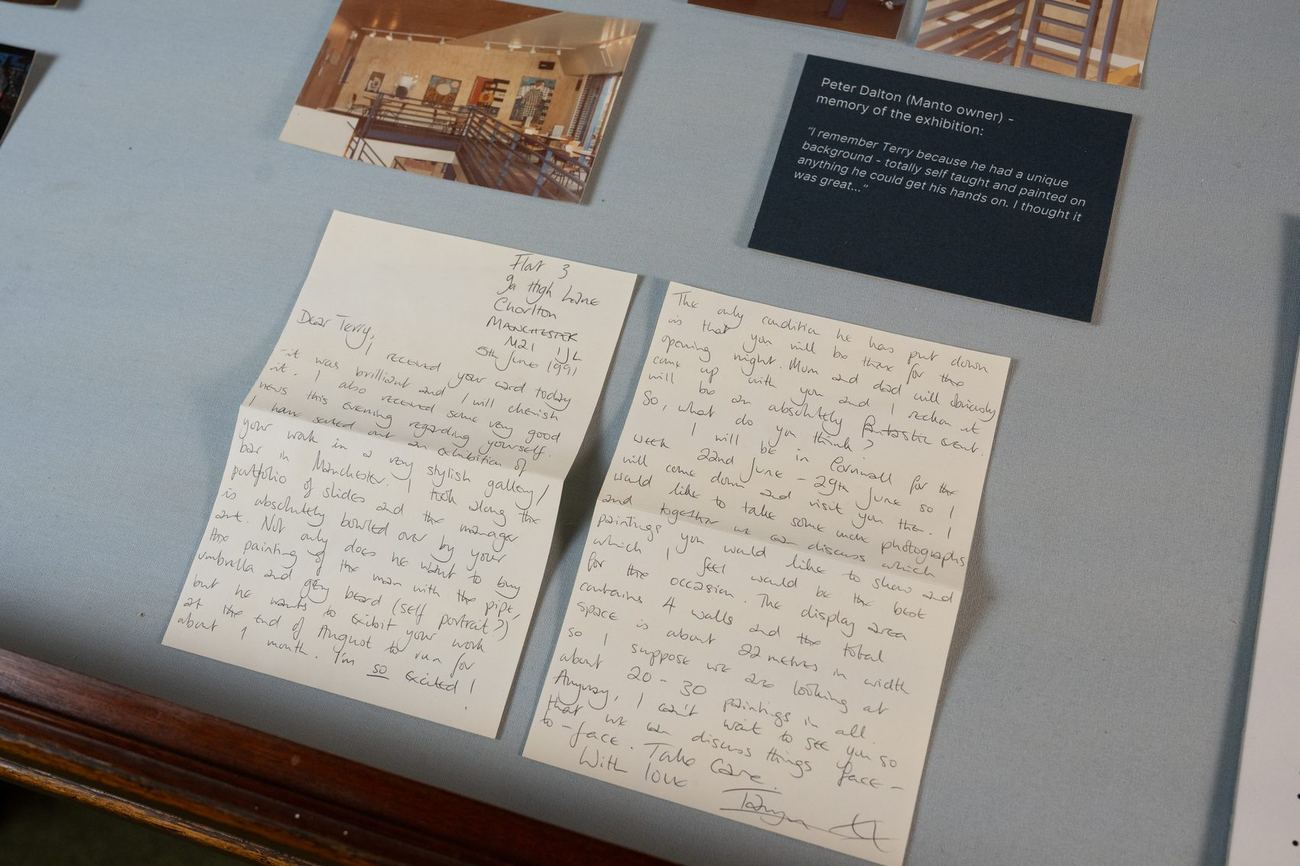 A handwritten letter from Terry Shaul, open in a display case