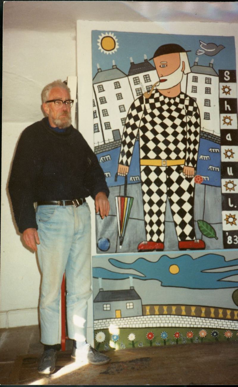 Terry Shaul standing beside his painting of a figure in a diamond suit